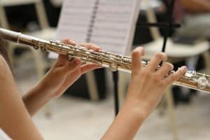 Mãos tocando flauta transversal